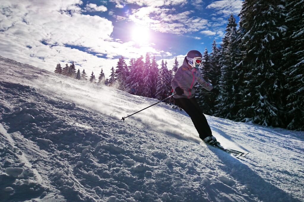 Skifahrerin mit Sonne im Hintergrund